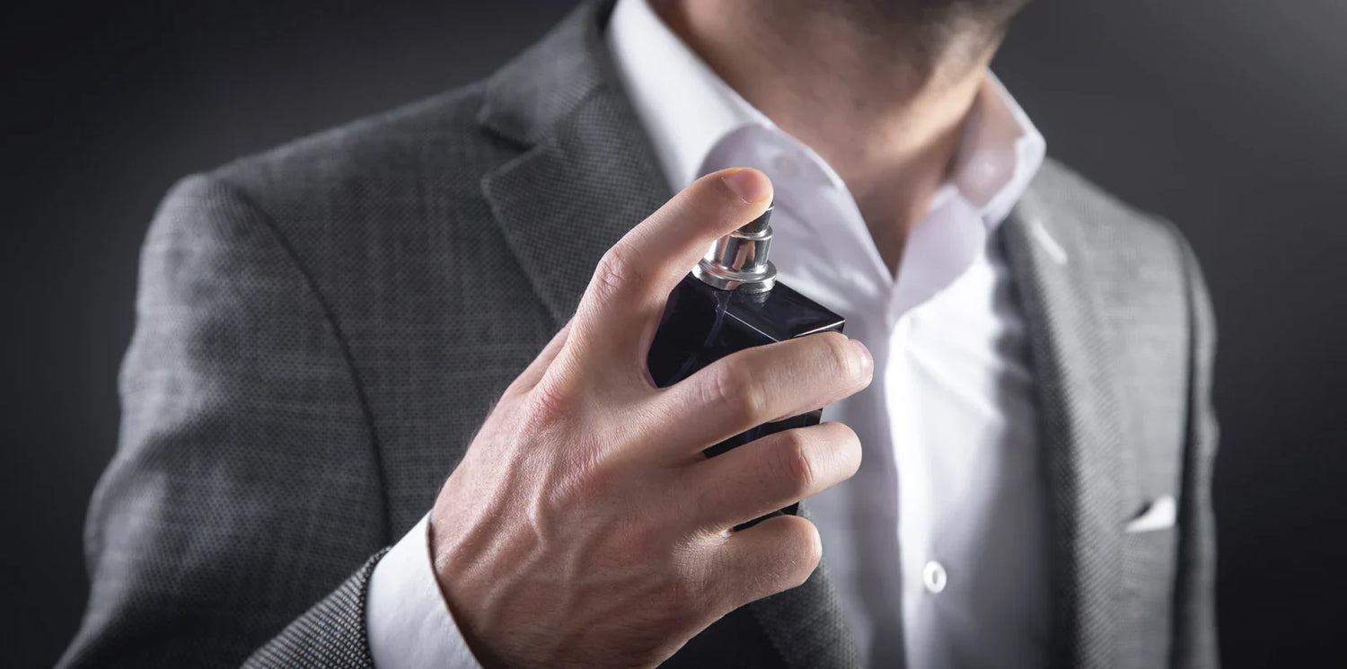 Men spraying perfume to the suit.